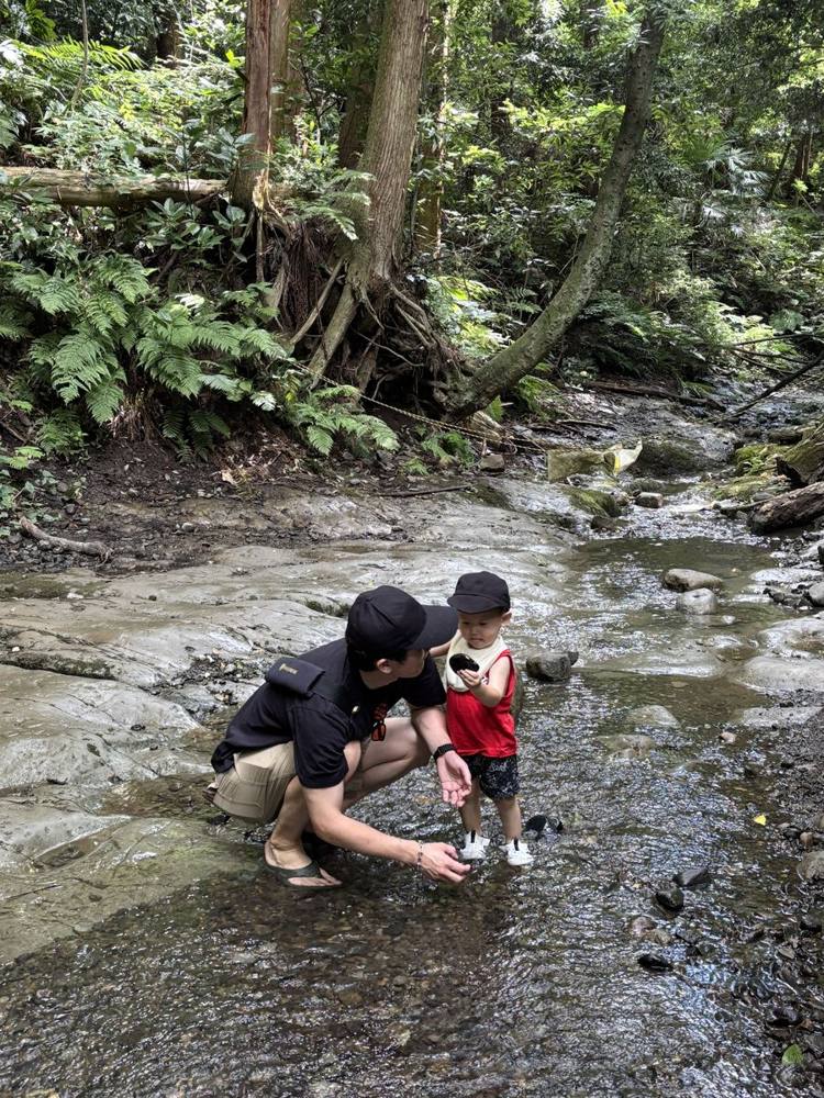 森の沢で、子どもと一緒に石を探しているところ